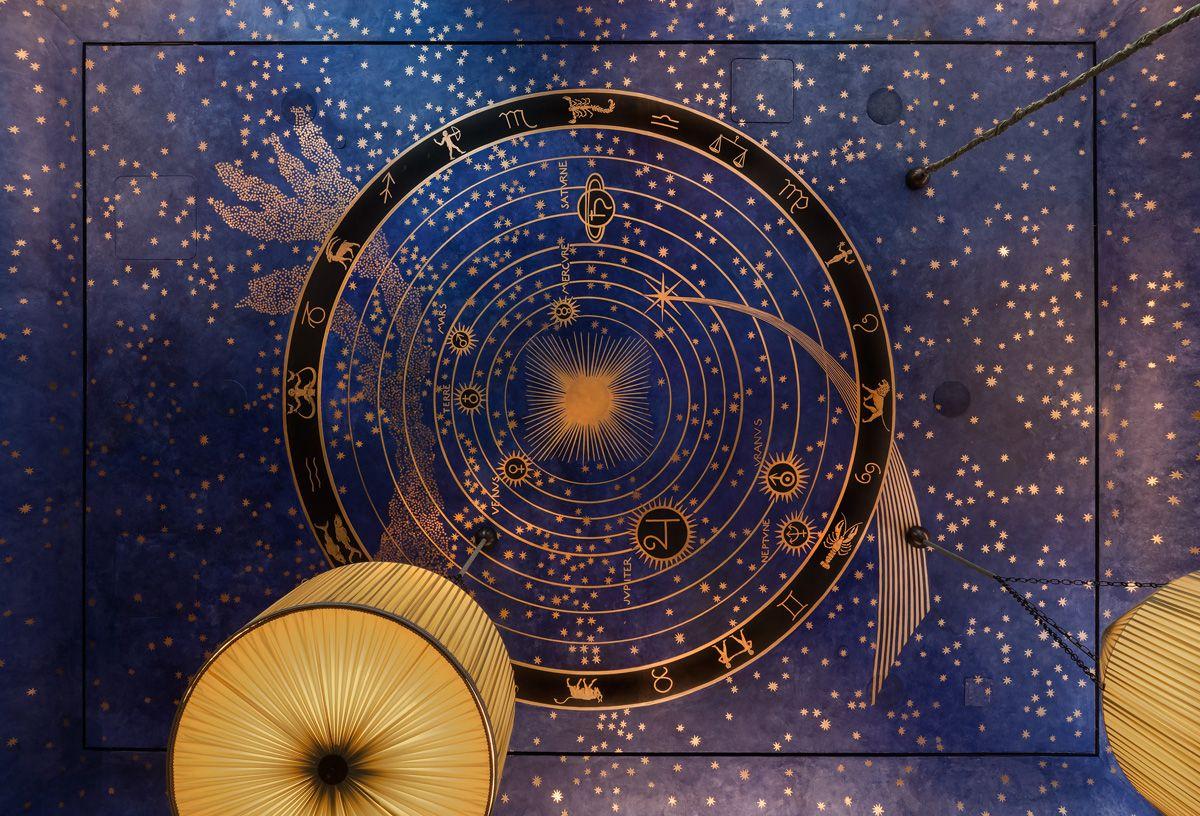 The ceiling of Albertine Books, a periwinkle blue with a gold and black circular astrological map.