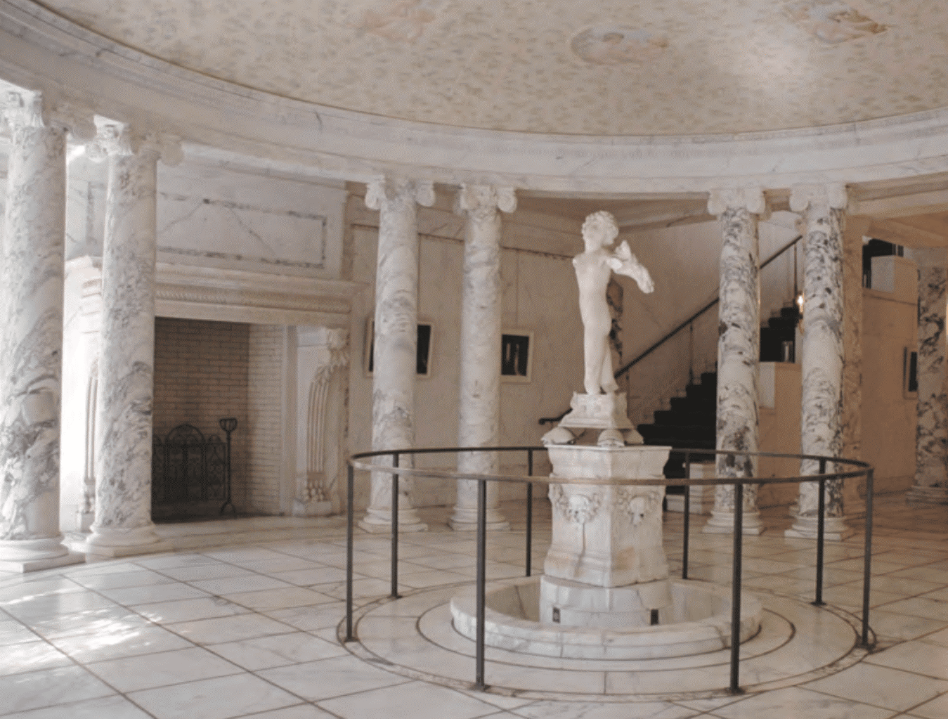 The marble rotunda, featuring the Young Archer statue attributed to Michelangelo, at the Payne Whitney Mansion