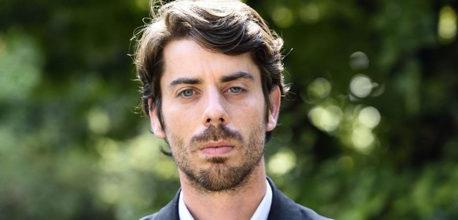 Adrien Bosc standing outside in suit crossing his arms
